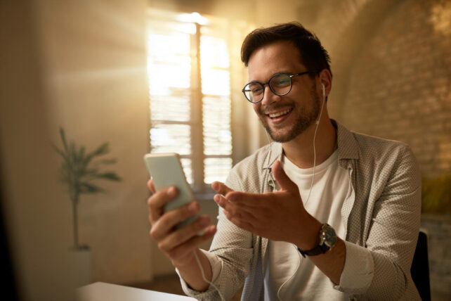 Jovem empresário feliz usando telefone celular