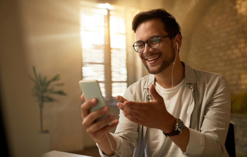 Jovem empresário feliz usando telefone celular